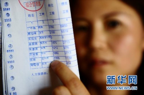 5月17日，中国铝业青海分公司职工张瑞向记者展示她4月份的工资条，工种一栏清楚地写着“会计师”。新华社记者张宏祥摄