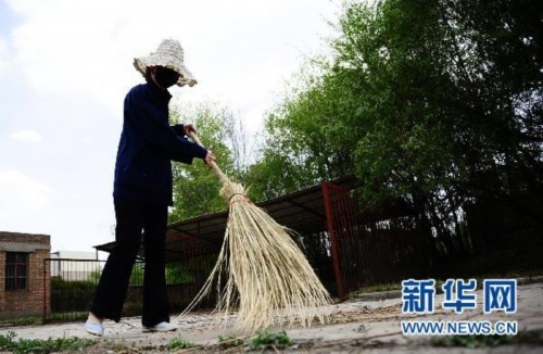 5月17日，中国铝业青海分公司职工罗静源在公司内清扫垃圾。新华社记者张宏祥摄