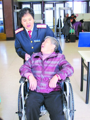 北京站女工作人员21年坚持推病残乘客上火车（图）