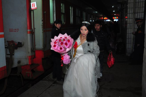 新娘穿婚纱坐火车回婆家 引路人围观祝福 