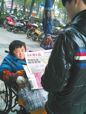 残疾女坐轮椅卖报19年不识字最希望能自己读报