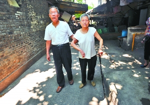 昨日，江北野水沟，92岁罗家强正扶着82岁老伴唐素芬散步锻炼。 重庆晨报记者 李斌 摄