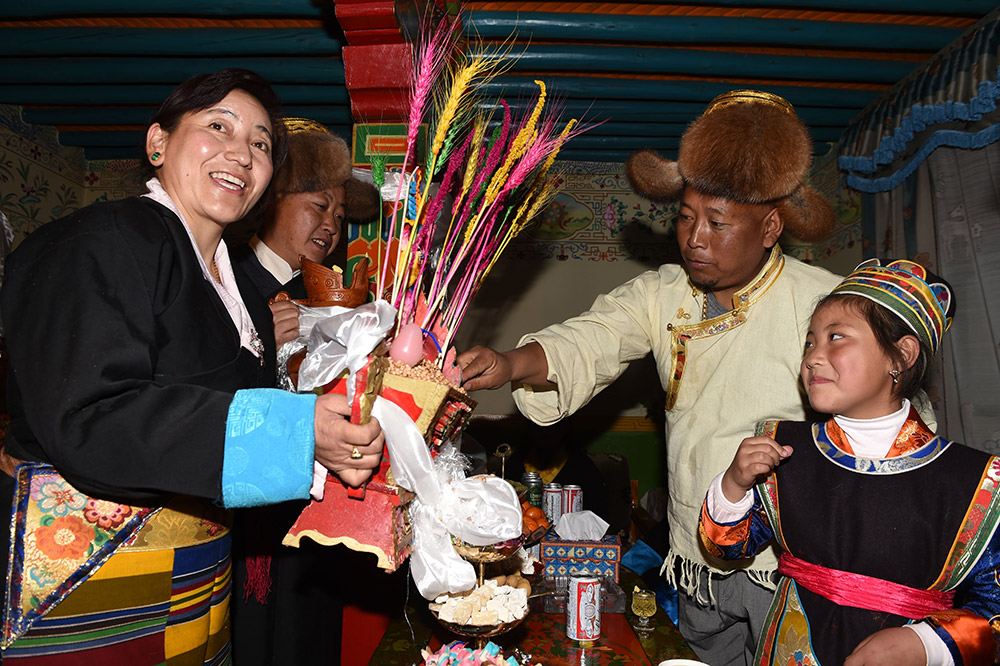 2月27日，拉萨市城关区阿坝林卡社区居民央拉（左）向邻居敬献“切玛”。